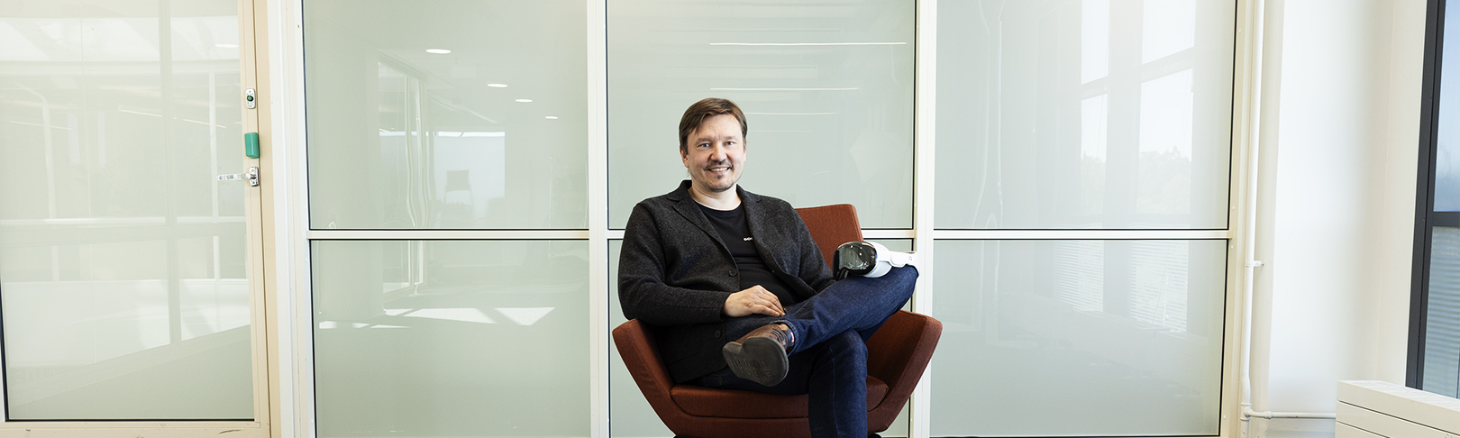 Sami Jahnukainen istuu tuolilla. Huoneen seinät ovat lasia.
